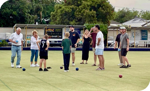 A group of happy people playing lawn bowls